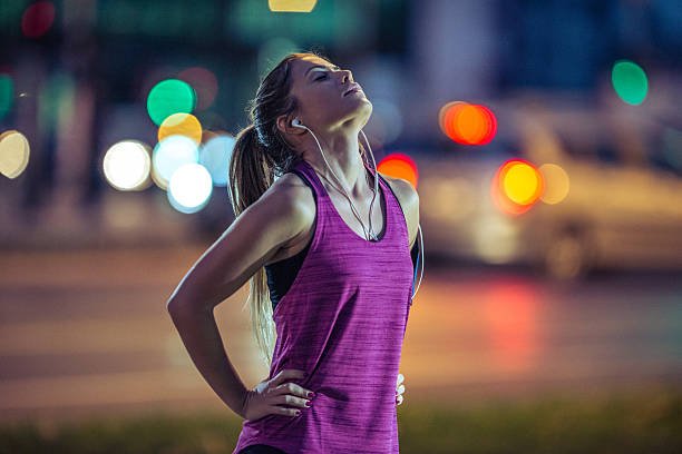 A young woman catching her breath after a running session.
